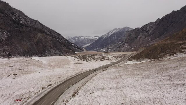 Aerial view of winter Chuikiy trakt road among Altai mountains. Road journey in winter