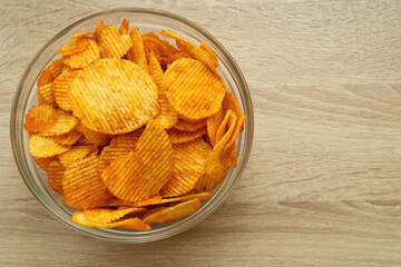Plate with potato chips on a wooden table. Space for beer snacks menu text.
