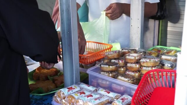 Indonesian street vendors who sell various kinds of sweet and salty cakes also sell wrapped rice. 