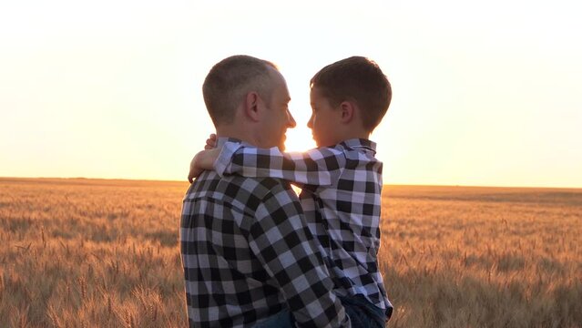 A father holds his son in his arms. Happy dad and baby look at each other at sunset Family business. The concept dream.