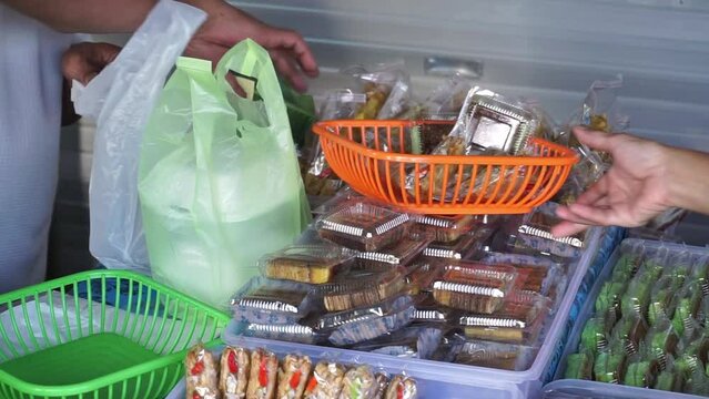 Indonesian street vendors who sell various kinds of sweet and salty cakes also sell wrapped rice. 