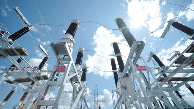 Many high voltage electrical insulators in power substation against blue sky background
