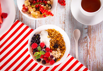 Granola, muesli cereals with yogurt or milk and fresh berries. Healthy breakfast concept.