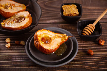 Honey or maple syrup roast pears with walnuts. Vegetarian diet health delicious dessert.