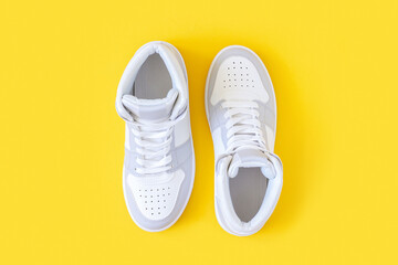 Sports shoes, sneakers with shoelaces on a yellow background. Sport lifestyle concept Top view Flat...