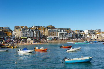 Fototapeta na wymiar St Ives, harbour with boats and high tide. Popular seaside town and port in Cornwall August 28 2022