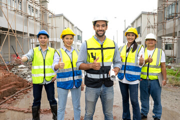 Chief engineer and foreman team celebrate residential project development success with smile at construction site. Group of successful construction workers enjoy working, and bonding with teamwork.