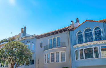 Fototapeta na wymiar Adjacent houses with italiante design against the clear blue sky in San Francisco, California