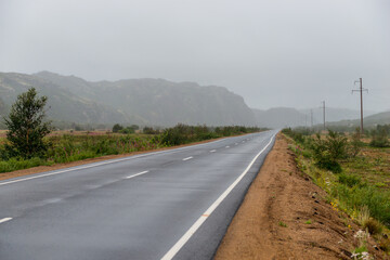 Asphalt road in polar tundra landscape. Far North of Russia