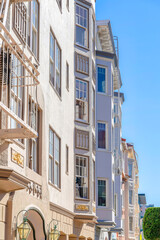 Row of apartments with painted stucco walls and victorian trims in San Francisco, CA