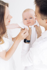 Young happy parents have fun and play with their baby boy.