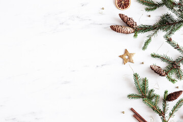 Christmas composition. Fir tree branches, christmas golden decorations on white marble background. Flat lay, top view, copy space - 529806103