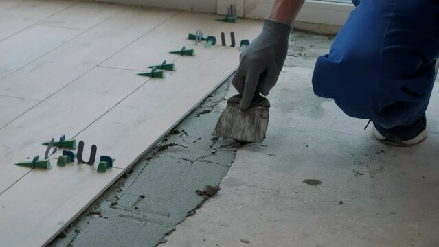 Construction, renovation, repair apartment. Installing ceramic floor tiles - measuring and cutting the pieces. Cuts tile. Tile cutting
