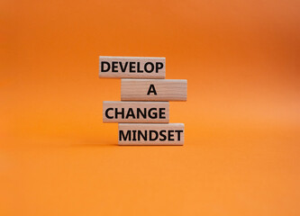 Develop a change mindset symbol. Concept words Develop a change mindset on wooden blocks. Beautiful orange background. Business and Develop a change mindset concept. Copy space.