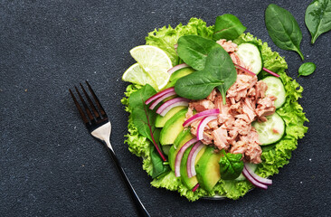 Tuna fish salad with avocado, cucumber, red onion, spinach and lettuce. White stone background, top view, copy space