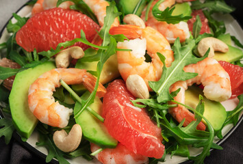 Healthy fresh salad with shrimps, avocado, grapefruit, arugula and cashews. Close up