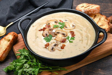 Mushroom champignon soup with bread and fresh mushrooms on a wooden background , autumn seasonal...