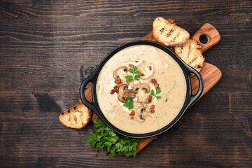 Mushroom champignon soup with bread and fresh mushrooms on a wooden background , autumn seasonal...