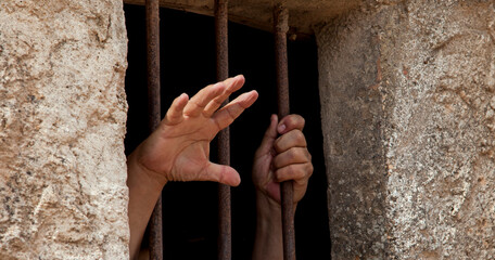hands behind bars asking for freedom