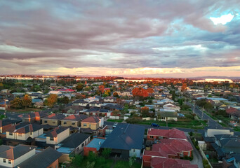 Panoramic aerial Drone view of Melbournes suburbs and CBD looking down at Houses roads and Parks Victoria Australia. Beautiful colours at Sunset