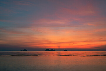 Obraz premium Colorful dramatic sky over the sea and islands. Reflections in the water.
