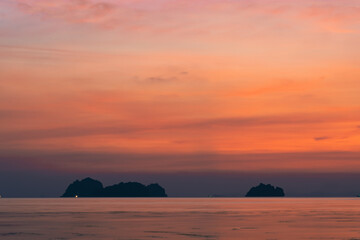 Colorful dramatic sky over the sea and islands. Reflections in the water.