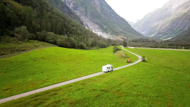 Aerial, drone following RV, family holiday trip in motorhome, Caravan car Vacation. Beautiful Nature Norway, natural landscape.