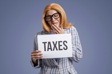 Businesswoman showing a sign with message about taxes