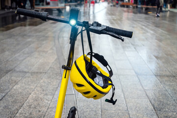 Electric scooter with beam light on and helmet ready for a ride