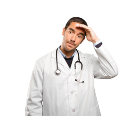 Fototapeta premium Stressed doctor against white background
