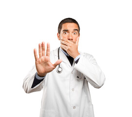 Scared doctor against white background