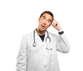Fototapeta premium Puzzled doctor against white background