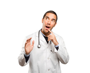 Surprised doctor against white background