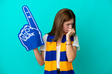 Young sports fan woman isolated on blue background having doubts