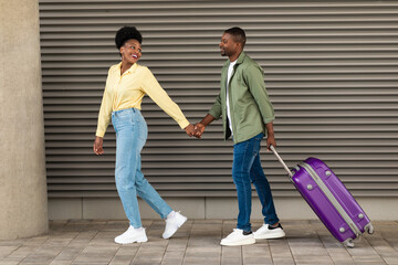 Happy African American Tourists Couple Walking With Suitcase Outdoors