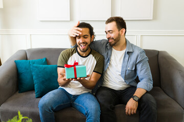 Romantic gay man giving his partner an anniversary gift