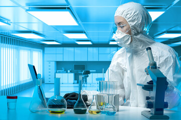 Bacteriological laboratories. Human in bacteriological protection suit. Study bacteria. Bacteriological woman is sitting at table. Girl in chemical protection suit in front of microscope and flasks - obrazy, fototapety, plakaty