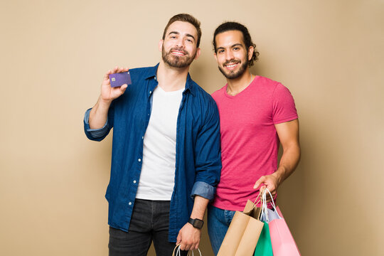 Happy Gay Couple Going Shopping Together With A Credit Card