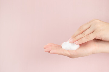 Fototapeta premium face foam, facewash mousse in a woman's hand, beauty skincare cosmetic