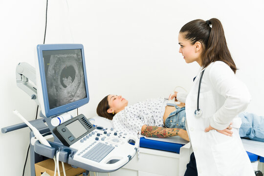 Technician checking the belly of a pregnant woman with a sonography at the imaging lab