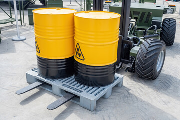 Chemical industry products. Barrels with dangerous liquid. Yellow barrels with radiation symbol. Unmanned forklift with metal containers. Barrels for chemical products. Transportation of chemicals