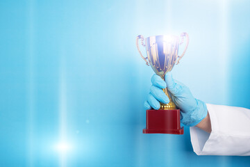 best doctor, medical award, golden cup in doctor's hands on blue background, copy space