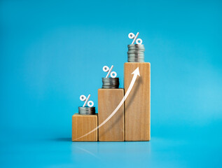 Shining rise up arrow on wooden cube blocks with percentage icon on coin stacked, bar graph chart...