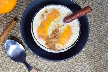 Delicious rice pudding with cinnamon and with a touch of orange, presented in a bowl.