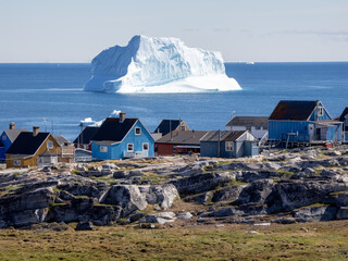 Huge icebergs lining the shores of the charming town of Qeqertarsuaq (formerly Godhavn) on the...