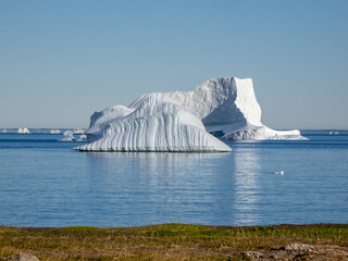 Huge icebergs lining the shores of the charming town of Qeqertarsuaq (formerly Godhavn) on the south coast of Disko Island, Western Greenland.