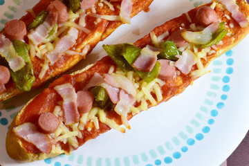Pizza bread, with mozzarella, tomato sauce, frankfurt, beacon and strips of green pepper.