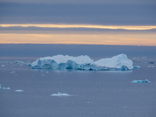 Enormous icebergs seen during the midnight sun, Disko Bay north of the Artic Circle near Ilulissat, Western Greenland