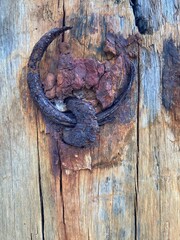 A corroded ring has rusted into a wooden beam
