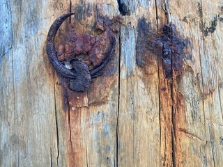 A corroded ring has rusted into a wooden beam